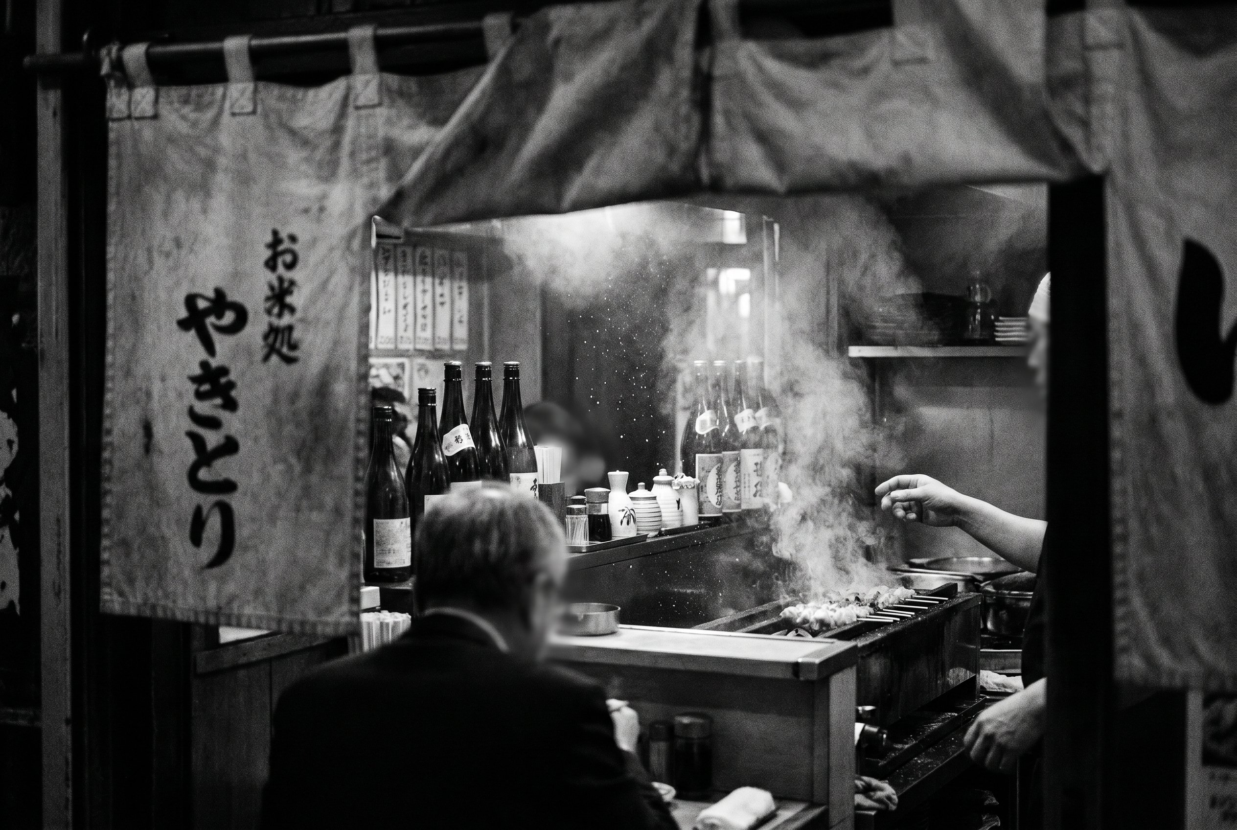 Yakitori counter, smoke through the entry